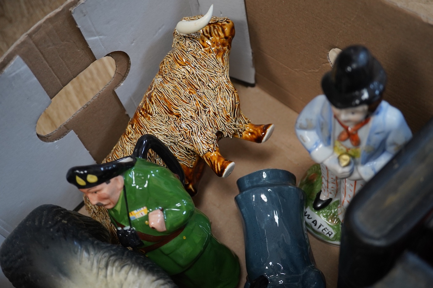 A pair of painted plaster figural bookends, a pottery Highland Cow and other Staffordshire figures etc (7)